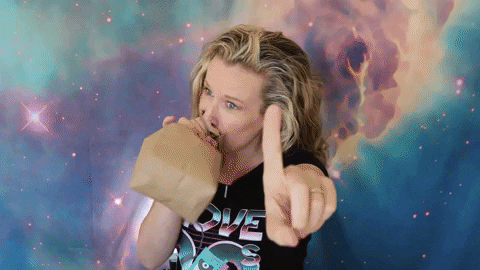 a gif depicting a woman breathing into a paper bag to calm down